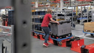 Operatorka ładuje przyczepę ciągnika logistycznego za pomocą wózka w niepełnym rozmiarze