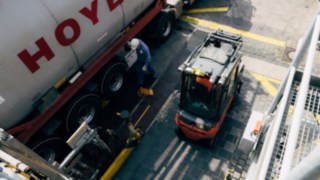 Wózek widłowy Linde w wersji przeciwwybuchowej stoi obok cysterny z chemikaliami. Wózek widłowy Linde w wersji przeciwwybuchowej stoi obok cysterny z chemikaliami.