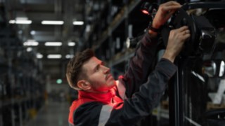 Systemy świetlne i ostrzegawcze Linde Material Handling umożliwiają bezpieczną i precyzyjną obsługę. Technik firmy Linde instalujący lampę VertiLight