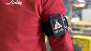 Distance Beeper od Linde pomaga zachować zdrowy, bezpieczny dystans. Distance Beeper od Linde na ramieniu pracownika