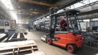 Wózki widłowe Linde Material Handling będą w przyszłości nadal wyznaczać nowe standardy w zakresie ergonomii i komfortu pracy operatora. Grupa osób analizuje środowisko pracy w hali logistycznej.