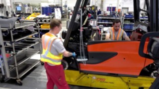 Również na obszarze produkcji zachowanie dystansu jest korzystne dla zdrowia- dzięki bezpiecznej kamizelce Distance Vest od Linde. Dwóch pracowników na produkcji zachowuje bezpieczną odległość dzięki kamizelce Distance Vest od Linde