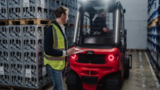 System wspomagania Linde Reverse Assist Radar podczas pracy. Pieszy przechodzi z tyłu wózka Linde X30.