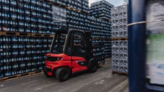 Zapewnimy odpowiednie rozwiązanie z zakresu bezpieczeństwa dla Twojej intralogistyki. Elektryczny wózek widłowy X30 transportuje skrzynki z napojami wąskim korytarzem w magazynie zewnętrznym.