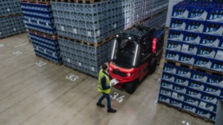 System wspomagania Linde Reverse Assist Radar wykrywa obiekty i osoby podczas cofania oraz ostrzega przed kolizjami. Elektryczny wózek widłowy X30 wyjeżdża tyłem z korytarza, w strefie za nim znajduje się pieszy.