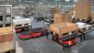 Kilka zautomatyzowanych platform mobilnych C-MATIC firmy Linde MH transportuje towary w magazynie firmy ABS Safety. 
