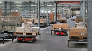 Zautomatyzowane platformy mobilne C-MATIC firmy Linde MH transportują skrzynie i palety po magazynie firmy ABS Safety,