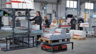 Zautomatyzowana platforma mobilna C-MATIC firmy Linde MH w otoczeniu grupy pracownic magazynu w firmie ABS Safety.