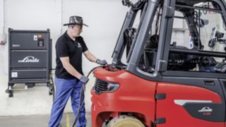 Sprawdzona wysokowydajna bateria Linde Li-ION zaopatruje napęd X35 w energię. Pracownik ładuje elektryczny wózek widłowy X35 firmy Linde