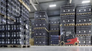 Ensinger Mineral-Heilquellen testuje nowy wózek Linde X35. Elektryczny wózek widłowy X35 firmy Linde Material Handling transportuje skrzynki z napojami w magazynie firmy Ensinger