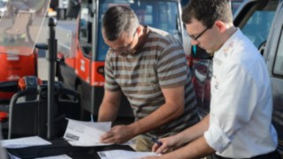 Pracownik firmy Linde wspólnie z Johannesem Kratzelem sprawdza protokół z przekazania wynajętych wózków Pracownik firmy Linde wspólnie z Johannesem Kratzelem sprawdza protokół z przekazania wynajętych wózków
