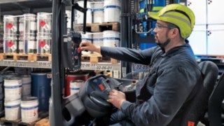 Pracownik firmy Inver GmbH steruje wózkiem widłowym wysokiego podnoszenia z ochroną przeciwwybuchową R14 EX firmy Linde MH.
