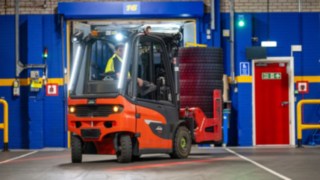 Pracownik Michelin Tyre PLC prowadzi wózek widłowy Linde Material Handling na biegu wstecznym.