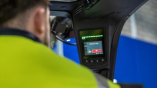 Wyświetlacz w kabinie operatora pokazuje komunikat ostrzegawczy z systemu Linde Reverse Assist Radar.