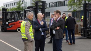 Do produkcji wodoru firma Linde wykorzystuje wyłącznie certyfikowaną ekologiczną energię elektryczną. Trzy osoby rozmawiają podczas otwarcia nowej instalacji do produkcji wodoru