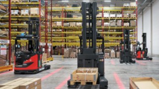 Wózki R-MATIC od Linde MH czekają przed regałem na kolejne zadania transportowe