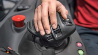 Kształt joysticka wielofunkcyjnego Linde jest precyzyjnie dostosowany do anatomii człowieka. Dłoń operatora wózka widłowego spoczywa na joysticku wielofunkcyjnym firmy Linde Material Handling