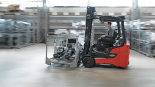 Grupa osób analizuje środowisko pracy w hali logistycznej.