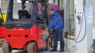 Zastosowanie napędów z bateriami litowo-jonowymi umożliwia regularne doładowywanie wózków. Pracownik dokonuje załadunku wózka widłowego firmy Linde Material Handling