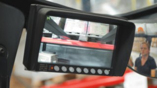 Na wyświetlaczu kamery widać dolną stronę ładunku i obszar regału Zamontowany na maszcie system kamer pomaga operatorowi bezpiecznie umieścić ładunek na regale