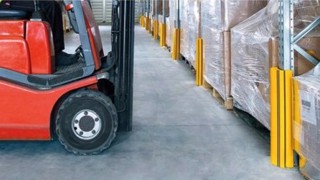 Żółto-czarne osłony regałów magazynowych RackGuard zabezpieczające nogi regału paletowego przed czerwonym wózkiem widłowym