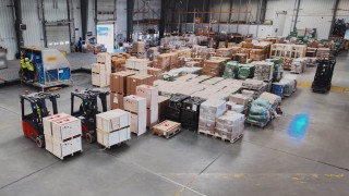 Flota używanych wózków widłowych z systemem bezpieczeństwa Linde Blue Spot pracująca w strefie cargo