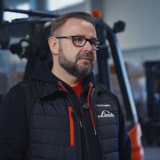Grzegorz Knochowski, Regionalny Dyrektor Handlowy Regionu Centrum Linde Material Handling Polska, stojący w magazynie na tle wózka widłowego