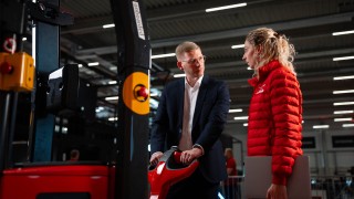 Dwie osoby w magazynie obok wózka widłowego do wynajmu krótkoterminowego