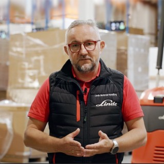 Grzegorz Napolski Manager ds Systemów Digitalizacji Linde Material Handling Polska stojący na tle magazynu TPV Displays