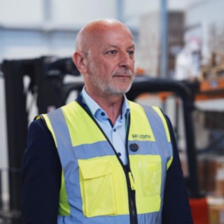 Paweł Kubinek Wicedyrektor pionu cargo Welcome Airport Services, stojący w magazynie na tle wózka widłowego